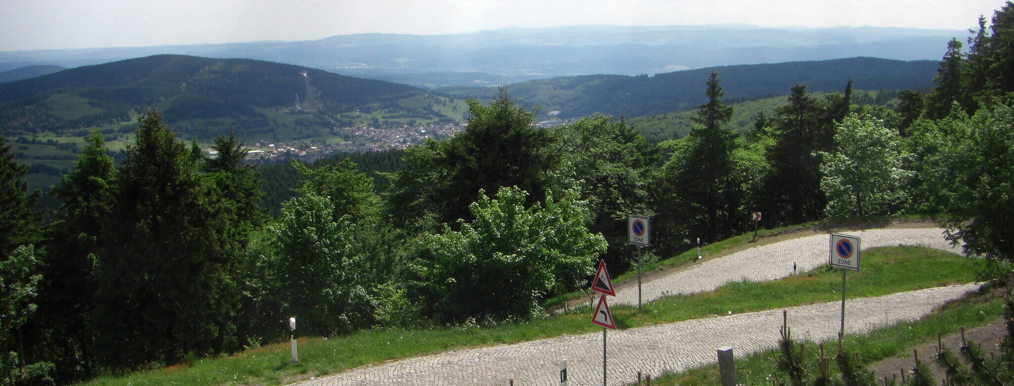 Ausblick über Brotterode, den Seimberg und die Inselsbergschanzen, im Vordergrund das letzte Stück der Auffahrt, wenn man sich am Parkplatz links hält.